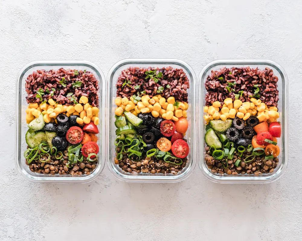 Three glass meal prep containers with different portion sizes